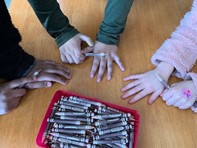 Image of children comparing skin tones to diverse crayons