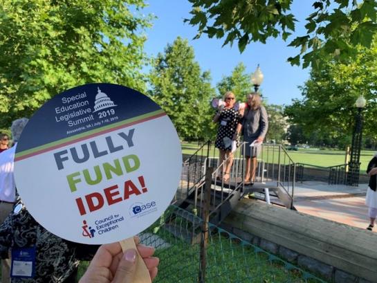 Advocate at 2019 SELS rally holding up "fully fund IDEA" sign