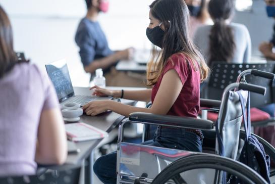 [image of a student in a wheelchair working at a desk]